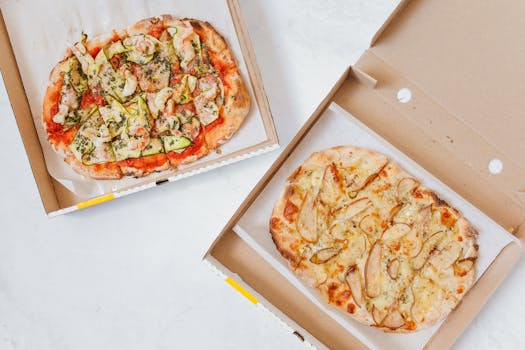 Freshly baked Italian pizzas in takeaway boxes viewed from above, showcasing gourmet flavors.